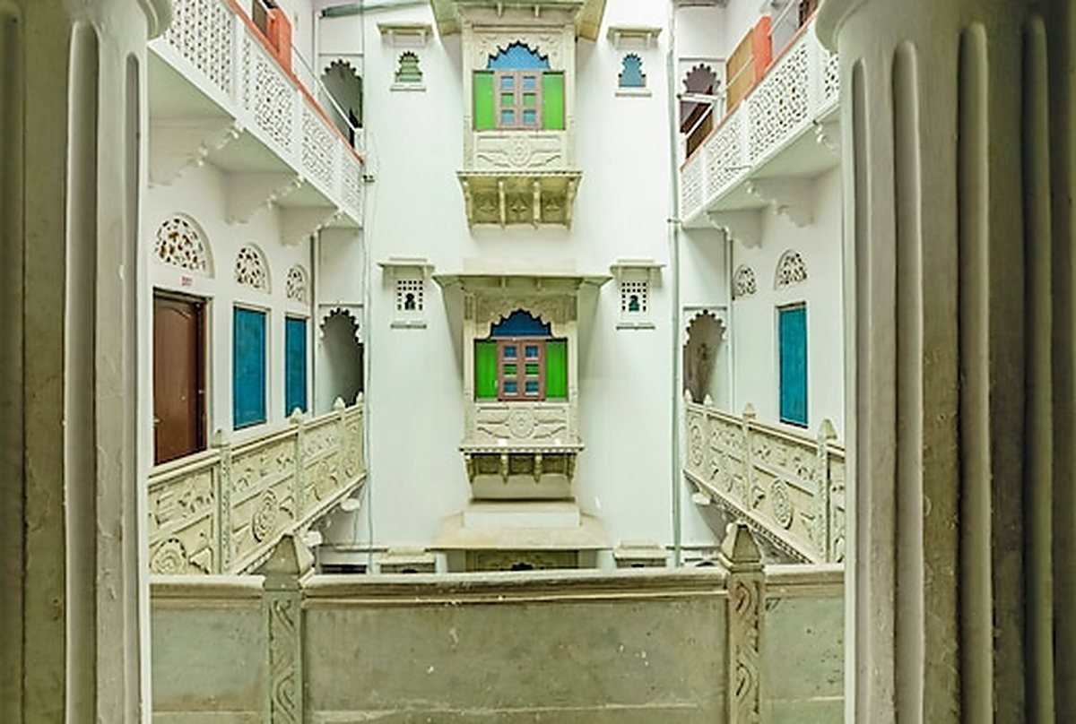 The lime-washed inner courtyard of the haveli with tiers of carved balconies