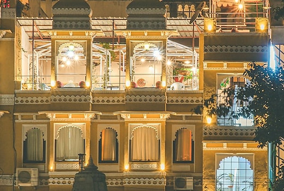 The illuminated balconies and arched windows of the haveli at night