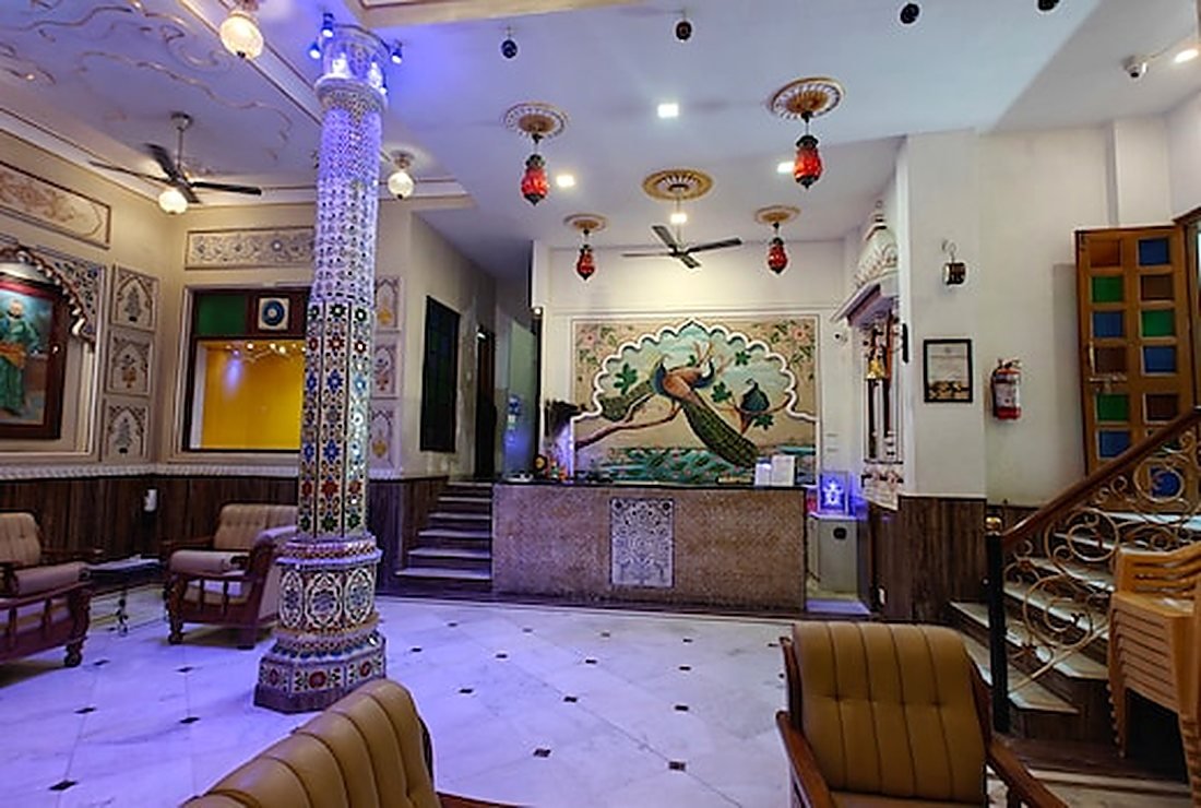 The entrance hall with a mirror-worked painted pillar, seating and the stair to the upper floors