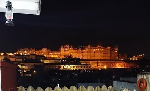 The City Palace of Udaipur illuminated at night, seen from the hotel's rooftop terrace